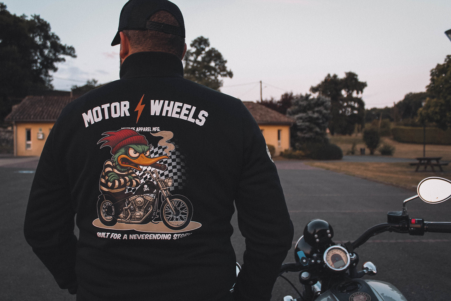 Veste noire Motor Wheels avec illustration cartoon d’un canard motard sur chopper et slogans vintage